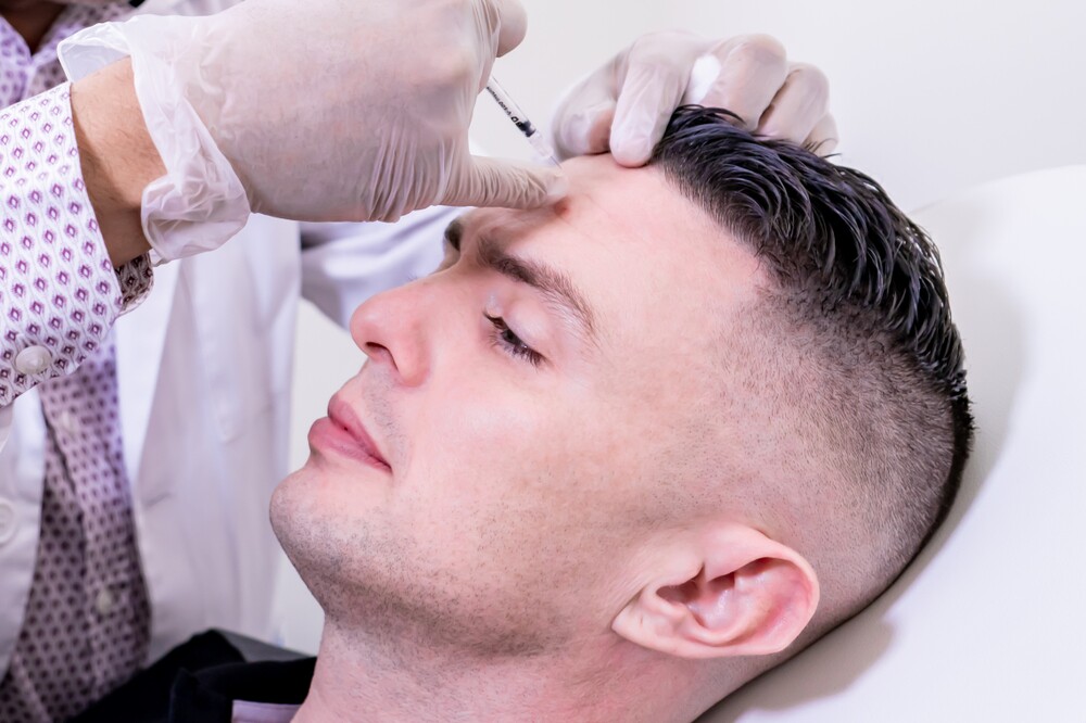 Botox-treatment-for-migraine-relief Doctor Administering Botox Injection To A Patient'S Forehead For Migraine Relief.